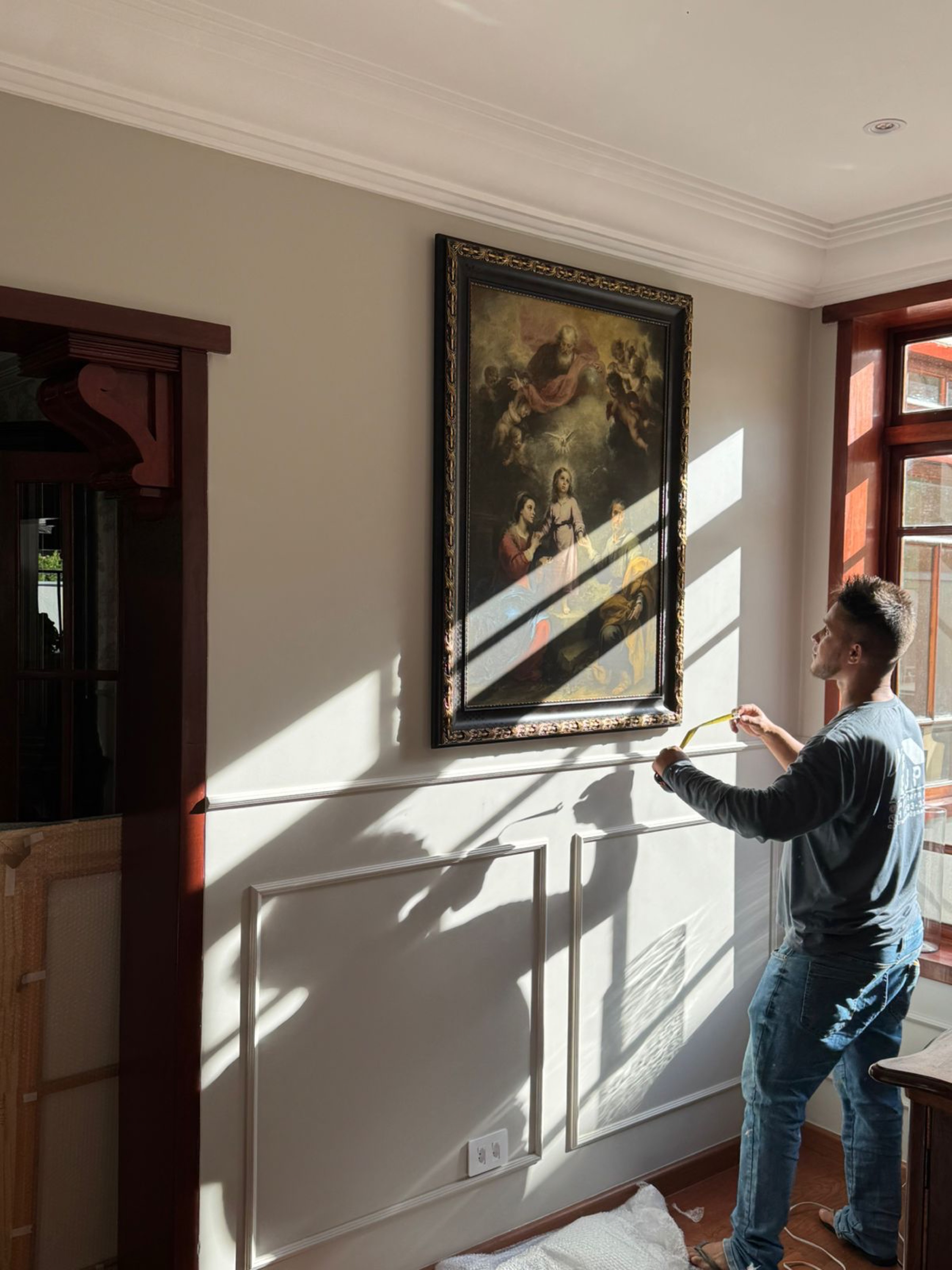 Equipe instalando quadro na casa do cliente