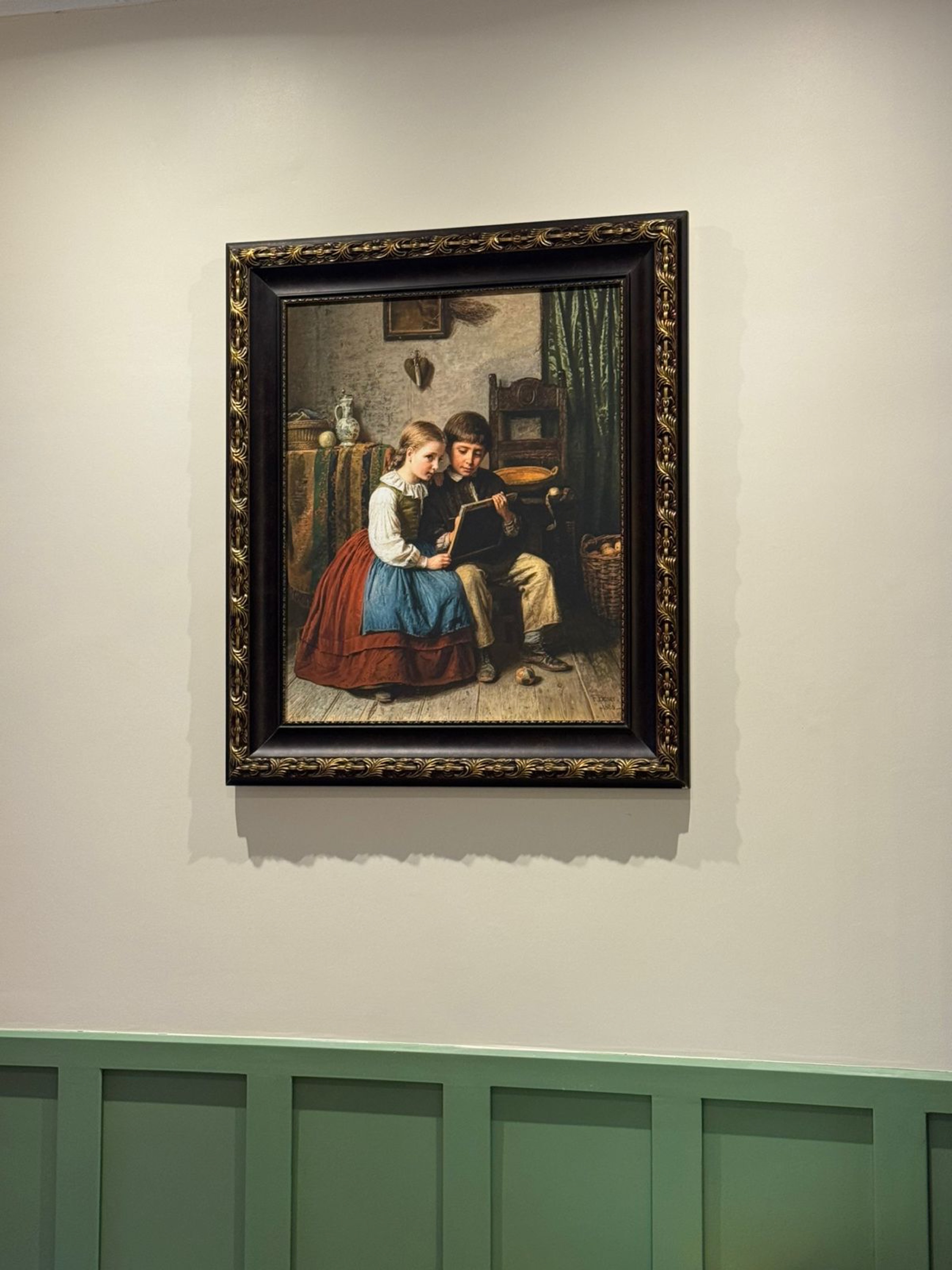 Crianças com quadro de escrita em parede com boiserie verde